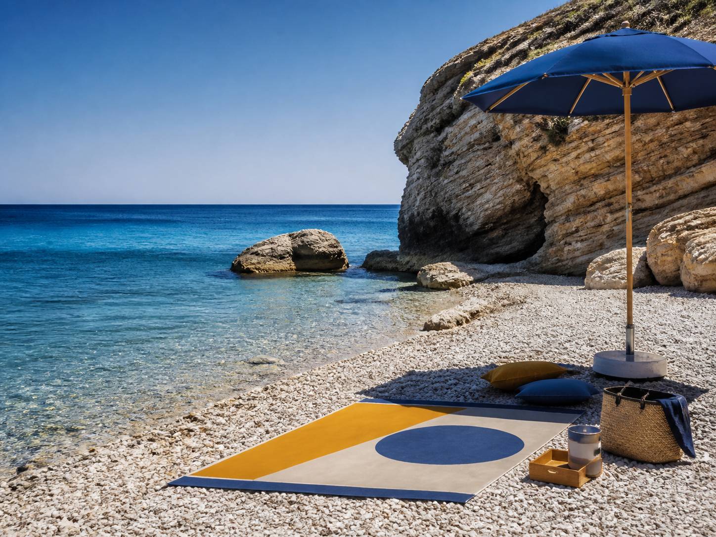 Plage de galets avec serviette et parasol au bord d'une eau claire