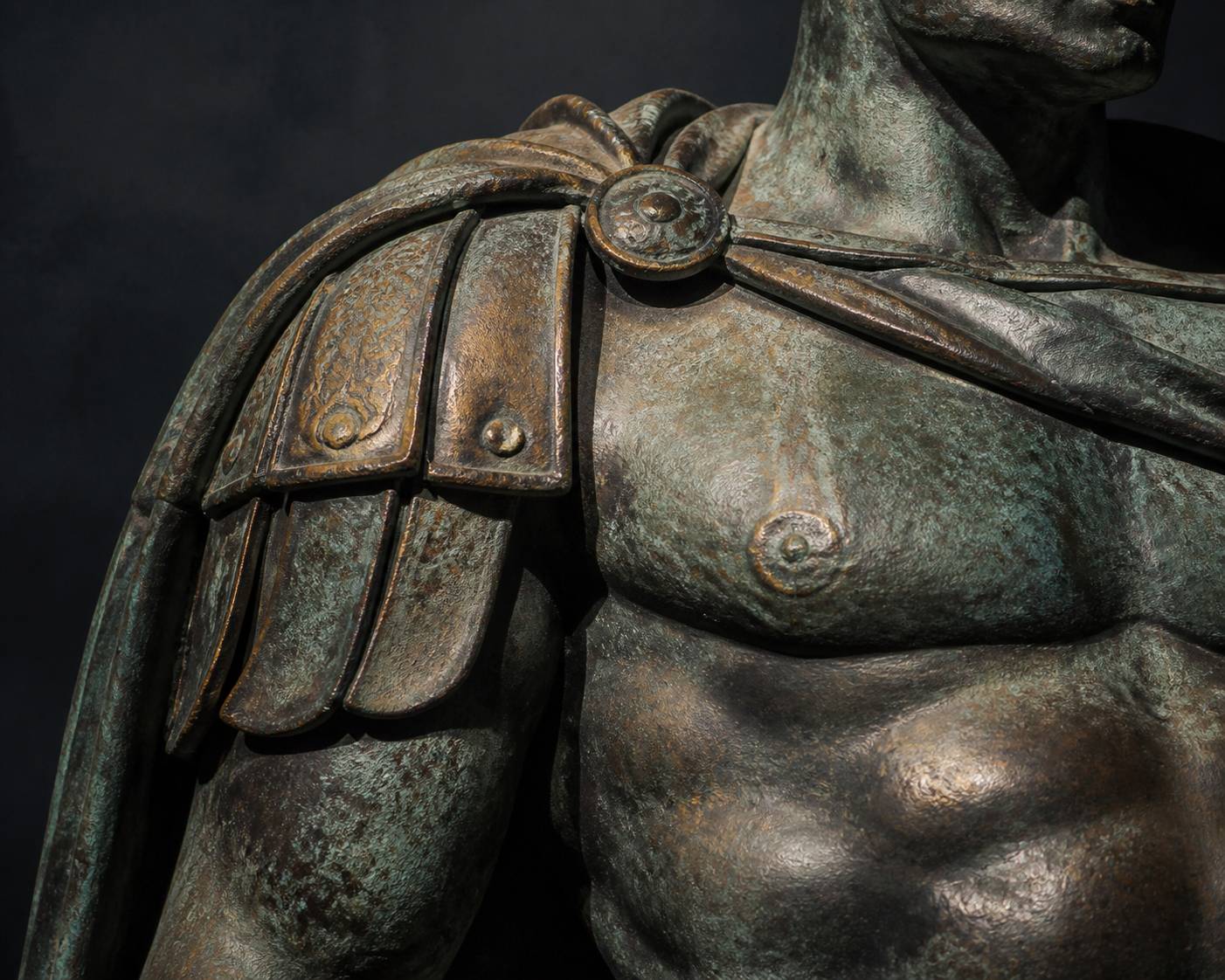 Gros plan sur le torse sculpté d'une statue de guerrier en bronze à la patine verte