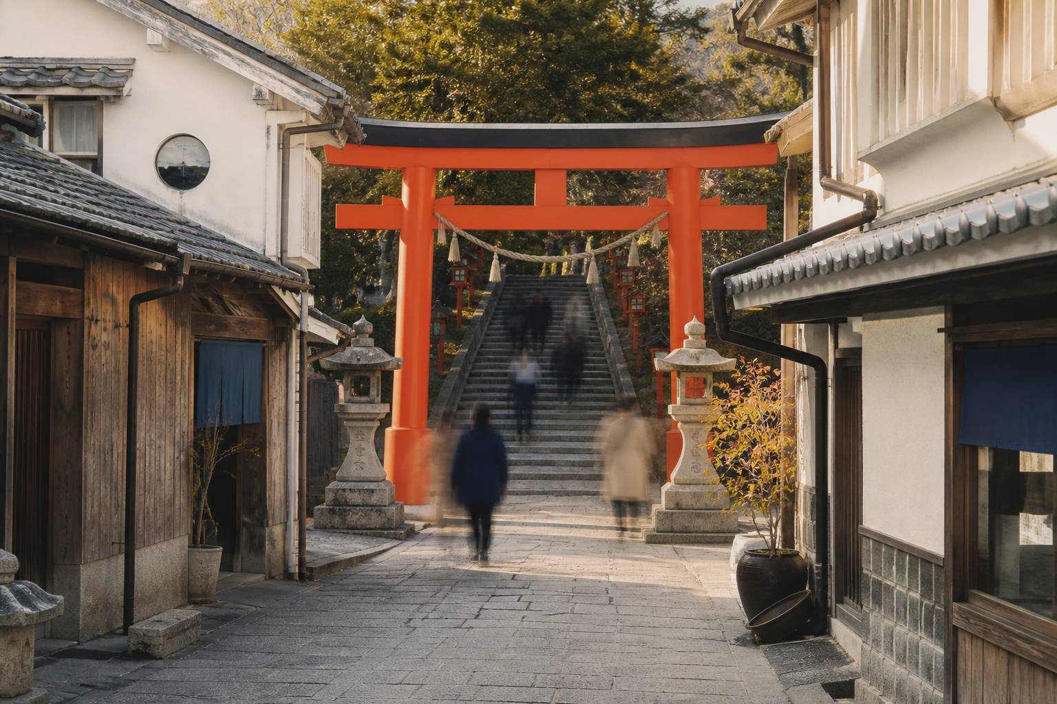 Torii rosso davanti a una scalinata di pietra con lanterne e case in legno
